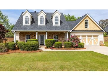 Charming home with stone accents, dormer windows, manicured lawn, and attached two-car garage at 3012 Keeneland Blvd, Mcdonough, GA 30252