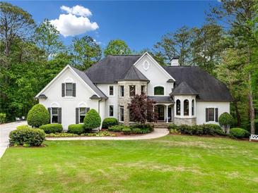Stunning two-story home with lush landscaping and a circular driveway creating exceptional curb appeal at 560 Indigo Dr, Roswell, GA 30075