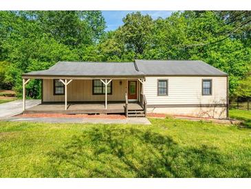 Charming single-story home with a welcoming front porch and well-maintained lawn at 6182 Silver Spur Dr, Lithonia, GA 30058