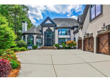 Stunning home features a large driveway, three-car garage, and professionally landscaped yard at 1114 Waterford Green Pt, Marietta, GA 30068