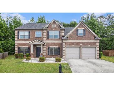 Charming two-story brick home with a well-manicured lawn and a two-car garage at 3225 Rex Ridge Dr, Rex, GA 30273