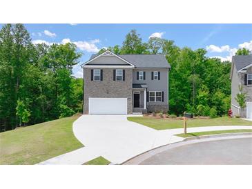 Charming two-story home featuring a combination of brick and siding, a two-car garage, and a well-manicured lawn at 1416 Clear Pond Lane, Dacula, GA 30019