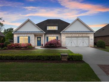 Charming one-story brick home with a well-manicured lawn and blue shutters offers a welcoming curb appeal at 4815 Amble Trce, Cumming, GA 30040