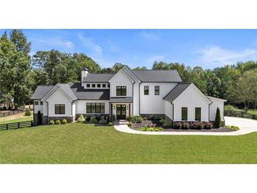 Stunning modern farmhouse with black trimmed windows and doors on an expansive manicured lawn at 445 Roper Rd, Canton, GA 30115
