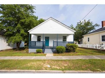 Charming single-story home featuring a quaint porch and beautifully maintained front yard at 27 Hazel St, Porterdale, GA 30014