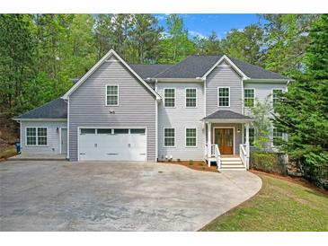 Beautiful two-story home with a manicured lawn, attached garage and inviting front porch at 552 Steels Bridge Rd, Canton, GA 30114