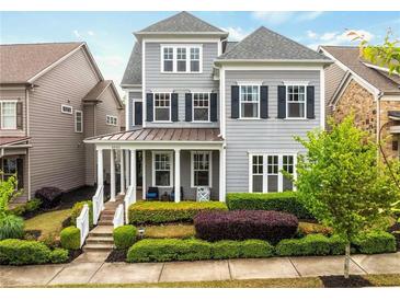 Charming two-story home with gray siding, manicured landscaping, and a welcoming front porch at 4020 Declaration Dr, Roswell, GA 30076