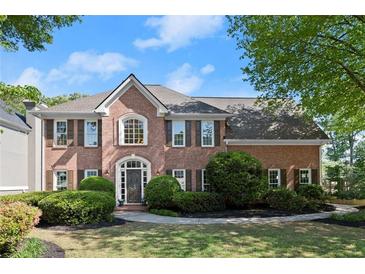 Charming brick home featuring a manicured lawn, tasteful landscaping and a welcoming front entrance at 5620 Preserve Cir, Johns Creek, GA 30005