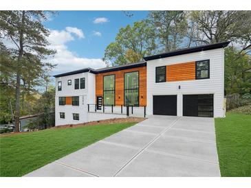 Modern two-story home featuring a concrete driveway, two-car garage, and eye-catching architectural details at 2396 Sunset Ne Dr, Atlanta, GA 30345