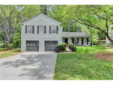 Charming two-story home with a two-car garage, landscaped yard, and covered front porch at 655 Barrington Way, Roswell, GA 30076