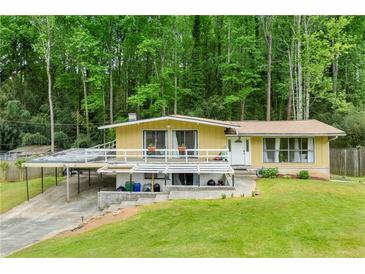 Unique home with a large deck and carport, nestled in a lush, wooded setting, providing privacy at 1188 Cedar Park Cir, Stone Mountain, GA 30083
