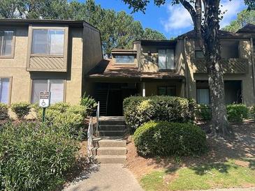 Inviting exterior view of a multi-level home with lush landscaping and stairs leading to the entrance at 114 Seasons Pkwy, Norcross, GA 30093