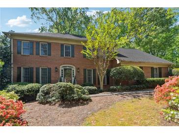 Beautiful brick home with green shutters, mature trees, and colorful landscaping at 3200 Turtle Lake Se Ct, Marietta, GA 30067