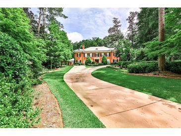 Stately red brick home with a long driveway surrounded by lush greenery at 3370 Habersham Nw Rd, Atlanta, GA 30305