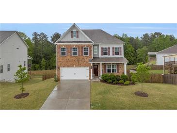 Charming two-story home featuring a brick facade and well-manicured front yard at 3510 Meadow Grass Dr, Dacula, GA 30019