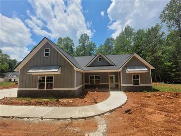 Charming new construction featuring stone accents, gray siding, and a welcoming walkway to the front door at 879 Highway 101 N, Dallas, GA 30157