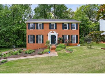 Charming two-story brick home with black shutters and a beautifully landscaped front yard at 682 Leighton Way, Stone Mountain, GA 30088