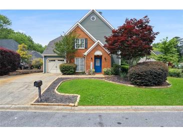 Charming brick and siding home featuring a well-manicured lawn and an inviting blue front door at 321 Hickory Sw Walk, Marietta, GA 30064