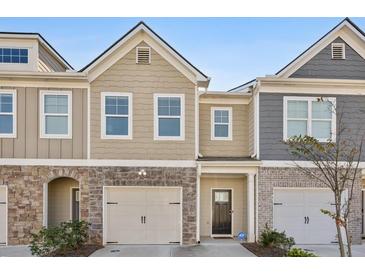 Charming townhome with a two-car garage and neutral siding, with a stone and brick accent at 5853 Greystone Dr, Lithonia, GA 30058