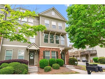 Charming townhome featuring a well-manicured front yard and inviting facade at 661 Village Field Nw Ct, Suwanee, GA 30024