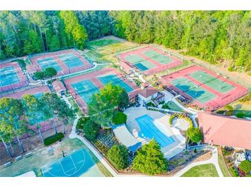 Aerial view of a community pool, tennis courts, and meticulously landscaped grounds with mature trees at 1336 Amberwood Dr, Woodstock, GA 30189