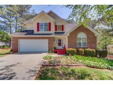 Charming two-story home with red accents, a well-manicured lawn, and a two-car garage at 3095 Willow Park Dr, Dacula, GA 30019