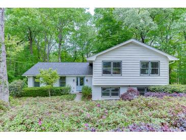Charming two-story home with a light blue door and beautifully landscaped front yard surrounded by lush green trees at 3460 Wycherly Ne Ct, Brookhaven, GA 30319