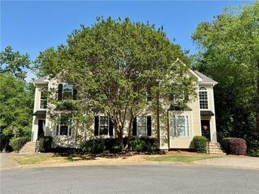 Beautiful townhome with lush greenery, two-story facade, and a shared driveway on a sunny day at 3650 Deep Cove Dr, Cumming, GA 30041