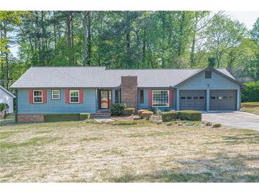 Charming home with a well-manicured lawn, blue siding and red shutters at 554 Cana Of Galilee Ct, Tucker, GA 30084
