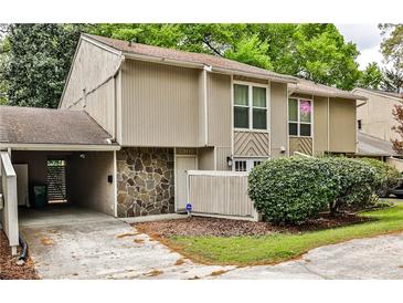 Inviting townhome features neutral siding, stone accents, and a convenient carport at 2302 Colonial Ne Dr, Brookhaven, GA 30319