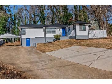 Charming home featuring white siding, a blue door, and a convenient carport with ample driveway space at 4175 Danforth Sw Rd, Atlanta, GA 30331