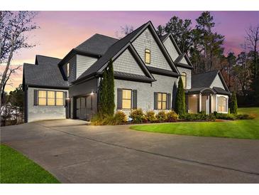 Beautiful grey two-story home featuring manicured landscaping and a spacious driveway leading to a two-car garage at 4370 Freys Farm Nw Ln, Kennesaw, GA 30152