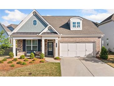 Charming brick and siding home with a two-car garage and inviting front porch seating area at 503 Forest Ln, Canton, GA 30114