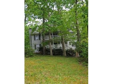 Two-story home nestled among mature trees with a large porch at 3876 Winners Ct, Marietta, GA 30062
