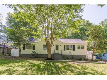 Charming one-story home with white siding, black shutters, and mature landscaping at 1050 N Carter Rd, Decatur, GA 30030