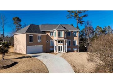 Charming home with a large front yard and driveway leading up to the attached garage at 4197 Trotters Way Dr, Snellville, GA 30039