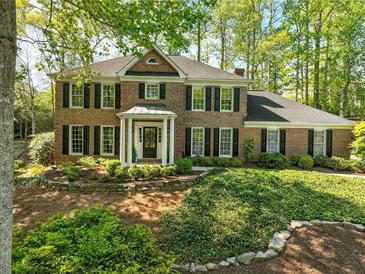 Charming brick home featuring a manicured front yard and mature trees at 5452 Tally Green Dr, Marietta, GA 30068