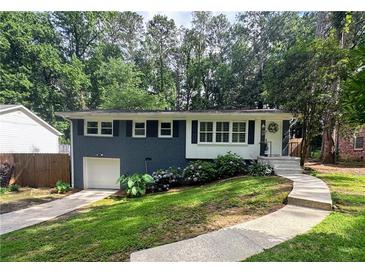 Charming home featuring a blue painted brick, white trim, and lush landscaping at 1907 Shalimar Ne Dr, Atlanta, GA 30345