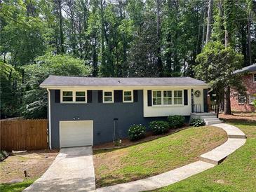 Charming single-story home with painted brick, white trim, an attached garage and a walkway up to the front door at 1907 Shalimar Ne Dr, Atlanta, GA 30345