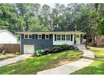 Charming one-story home featuring a combination of brick and white wood with inviting curb appeal and a lovely landscape at 1907 Shalimar Ne Dr, Atlanta, GA 30345