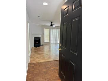 Inviting living room with a fireplace and ceiling fan, filled with natural light from the big windows at 2080 Charter Ln, Lithonia, GA 30058