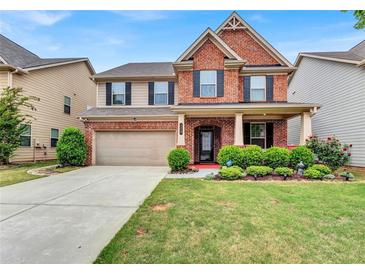 Inviting two-story home featuring a well-manicured lawn and a brick facade, creating a charming curb appeal at 3259 Baylor Cir, Mcdonough, GA 30253