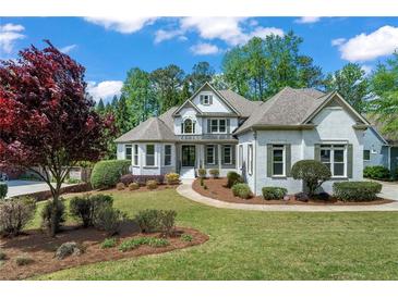 Charming two-story brick home with a well-manicured lawn and lush landscaping at 1749 Patriots Nw Way, Kennesaw, GA 30152