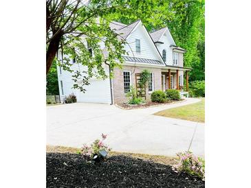 Charming brick and white two-story home with an attached garage and a well-manicured lawn at 2870 Willow Wisp Way, Cumming, GA 30040