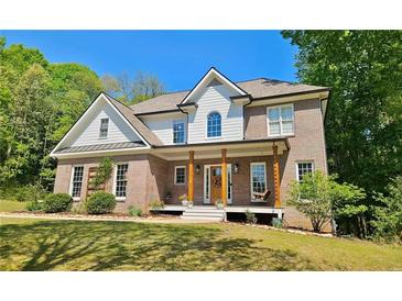 Charming two-story brick home with a welcoming front porch and manicured lawn at 2870 Willow Wisp Way, Cumming, GA 30040