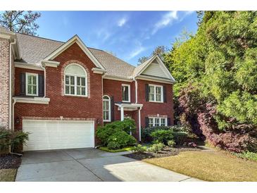 Charming brick home with manicured lawn, two-car garage, and inviting curb appeal at 104 Glentown Way, Sandy Springs, GA 30328