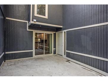 A cozy outdoor patio with a sliding door and a white door to enter into the house at 1022 Mariners Ct, Stone Mountain, GA 30083