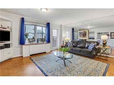 Bright living room with modern decor, hardwood floors, and a stylish blue accent rug at 300 Peachtree Ne St # 22N, Atlanta, GA 30308