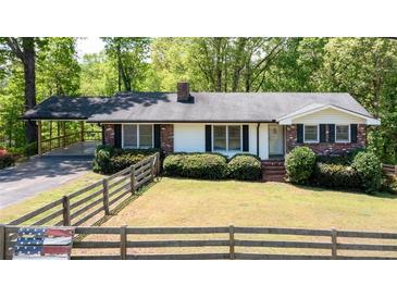 Charming ranch-style home with a well-manicured lawn and mature trees, offering a peaceful and inviting curb appeal at 4265 Hurt Bridge Rd, Cumming, GA 30028