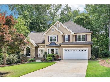 Charming two-story traditional home with well-manicured lawn, two-car garage and lush landscaping at 989 Pinfeather Ct, Lawrenceville, GA 30043